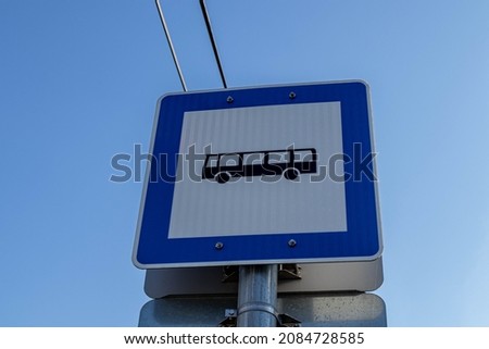 A white and blue bus stop sign in Csillaghegy, Budapest, Hungary on a sunny autumnn day.