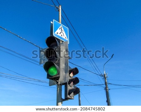 Traffic light and poles and pedestrian crossing sign