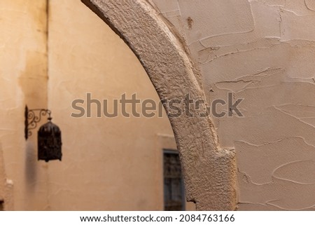 Arabic style lamp on the wall of a typical middle eastern architecture style building with arches and tourism decorations . High quality photo