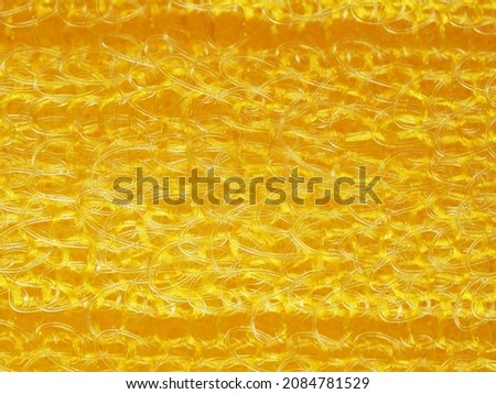 close up, background, texture, large horizontal banner. heterogeneous surface structure bright saturated yellow sponge for washing dishes, kitchen, bath. full depth of field. high resolution photo Royalty-Free Stock Photo #2084781529