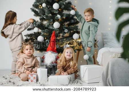 Children under the Christmas tree with gifts and toys