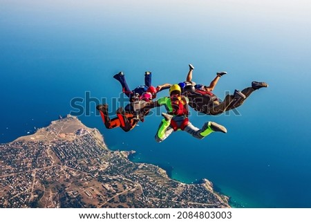 Skydiving group over the sea Royalty-Free Stock Photo #2084803003