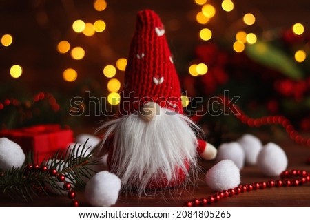 Funny toy gnome against Christmas festive decorations. Selective focus. Christmas or New Year greeting card