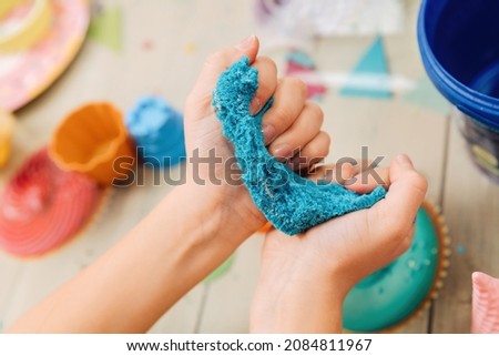 kinetic sand. children's hands play with multi-colored polymer sand. Royalty-Free Stock Photo #2084811967