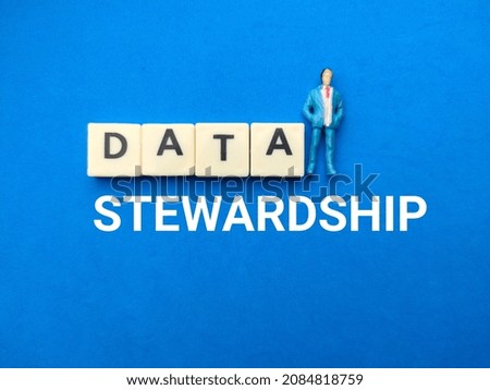 Miniature people with text DATA STEWARDSHIP on blue background. Royalty-Free Stock Photo #2084818759