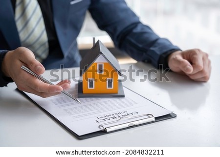 The real estate agent is explaining the contract to rent or buy, inspect the sample home and Business contract, lease, purchase, mortgage, loan or home insurance documents