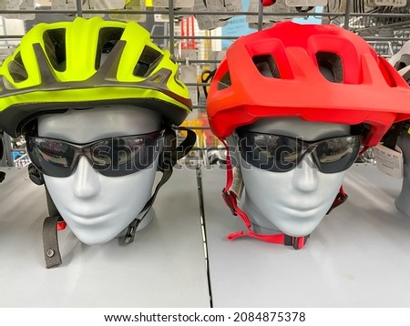 Close up image of two mannequins wearing cycling sports helmet and black sunglasses 