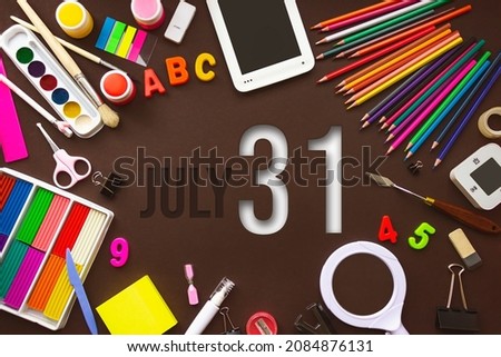 July 31st . Day 31 of month, Calendar date. School notebook and various stationery with calendar day. School and office supplies frame. Summer month, day of the year concept
