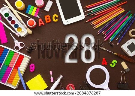 November 28th. Day 28 of month, Calendar date. School notebook and various stationery with calendar day. School and office supplies frame. Autumn month, day of the year concept