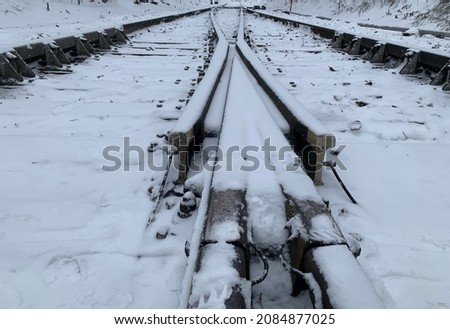 CloseUp of Two railways merge in to one railway under snow.Close up of Two railroads merge into one railroad under snow. Snow on railway (railroad). Close up of railroad in winter (railway). Royalty-Free Stock Photo #2084877025