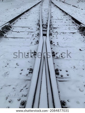 CloseUp of Two railways merge in to one railway under snow.Close up of Two railroads merge into one railroad under snow. Snow on railway (railroad). Close up of railroad in winter (railway). Royalty-Free Stock Photo #2084877031