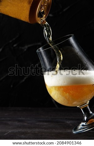 Beer pouring into a glass wooden table dark wall