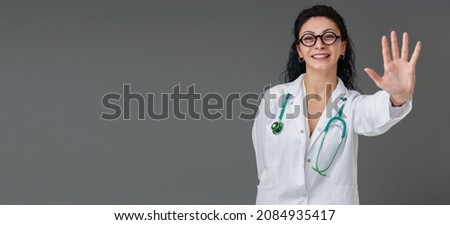 Beautiful smiling Turkish young doctor woman portrait. She wears eyeglasses. She is confident mood. Tips and tricks concept.