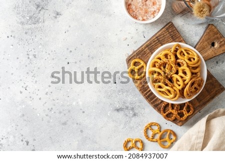 Mini pretzels with salt in a white bowl on a bright kitchen table Royalty-Free Stock Photo #2084937007