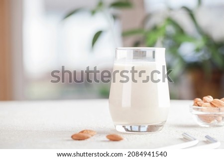 Vegan almond milk in glass with nuts on blurry background. Copy space. Healthy vegetarian food. selective focus. Non dairy alternative milk