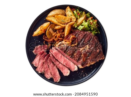 Top view of delicious grilled beef steak and rustic potatoes wedges with vegetable salad served on plate on white background Royalty-Free Stock Photo #2084951590