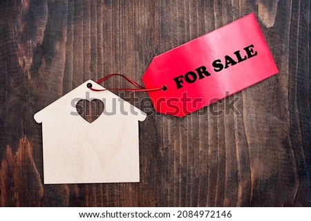 Miniature house with a red sign for sale. Real estate purchase, property insurance, cute house ecology rental concept