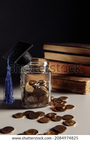 Savings for education concept. Coins in jar with graduation cap. Vertical image