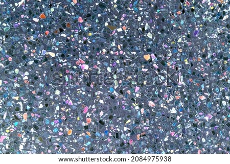 surface of a wall with small pieces of super colored stone, looks like splashes of colors. unreal with color treatment. Texture for backdrop floor