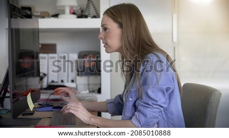young female graphic designer working on her computer in a sart-up
