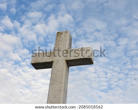 cross made of stone with blue sky background