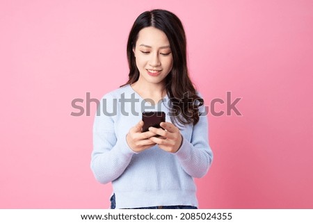 Portrait of a beautiful young Asian girl, isolated on pink background