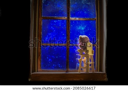 Children's rocking chair against the background of the starry sky outside the window at night
