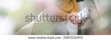 Businesswoman and businessman shaking hands; panoramic banner