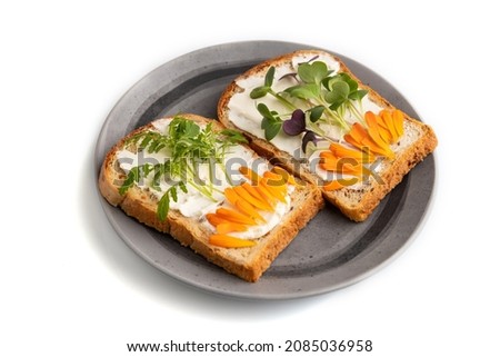 White bread sandwiches with cream cheese, calendula petals and microgreen radish and tagetes isolated on white background. side view, close up.