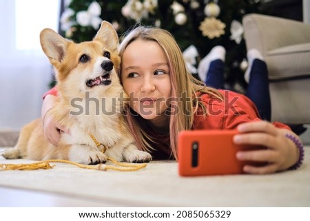 Friendship Concept. Teenage girl taking selfie with her dog at home. Dog lover with domestic animal