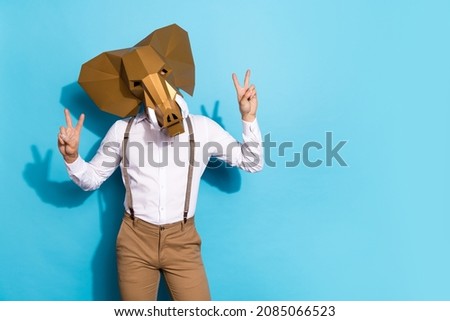Photo of wacky eccentric man wear elephant mask showing two v-signs empty space isolated blue color background