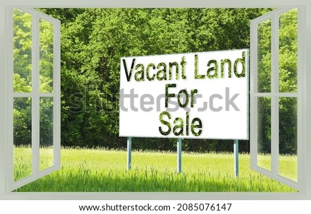 Advertising billboard immersed in a rural scene with Vacant Land for Sale written on it - concept image seen through a window.