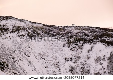 Hiker standing on the lip of the Kerid Crater in Iceland.
