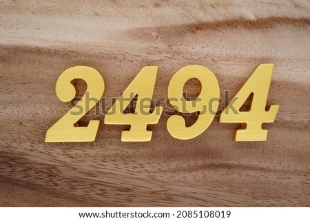 Golden Arabic numerals 2494 on a dark brown to white wood grain background.