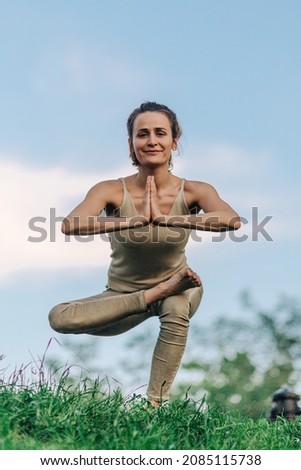 beautiful girl doing yoga poses on the sunset in the park, balance, fitness, stretching and relaxation
