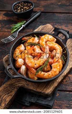 Roast Prawns Shrimps in a pan with herbs and garlic. Dark wooden background. Top view Royalty-Free Stock Photo #2085129601