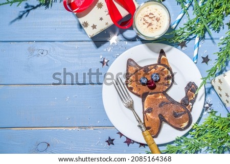 Christmas New Year morning breakfast, kids festive brunch snack. Funny  tiger pancakes, creative New Year 2022 symbols pancakes made with with berries, chocolate and vanilla dough