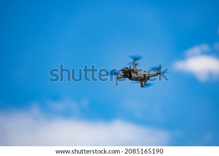 Drone flying in blue sky with a few clouds 