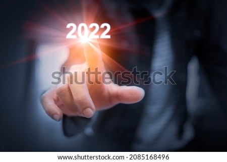 Business man's hands Touching numbers 2022 and a light flashed out