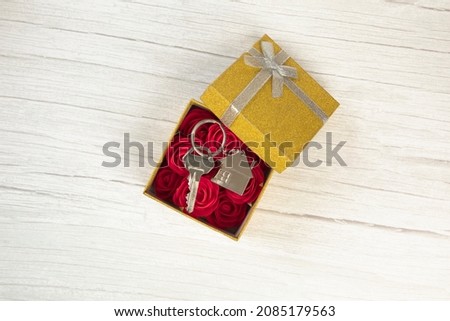 Silver new keys in golden sparkling gift box for buying new house, present, real estate concept top view, copy space space for text