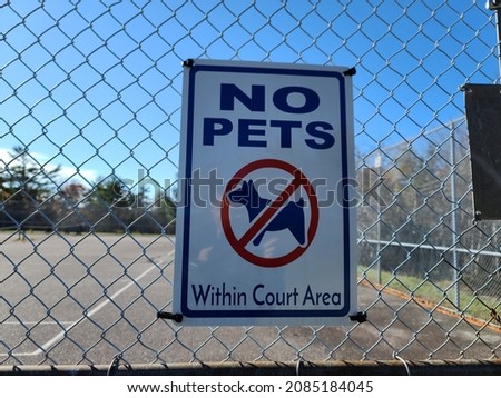 A sign indicating that pets aren't allowed. There is a symbol showing no dogs in the court area.