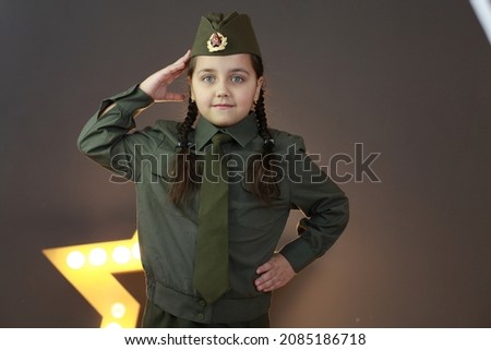 Portrait of little girl in green uniform. Happy veteran day celebration. Memorial day respect and victory concept. Veterans Day. Holiday and school uniform