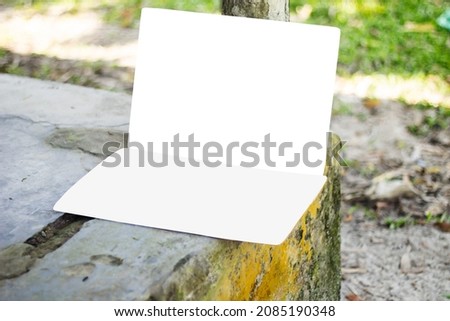 There are two blank white signboards leaning against the old walls with a pole and their backgrounds are blurred.