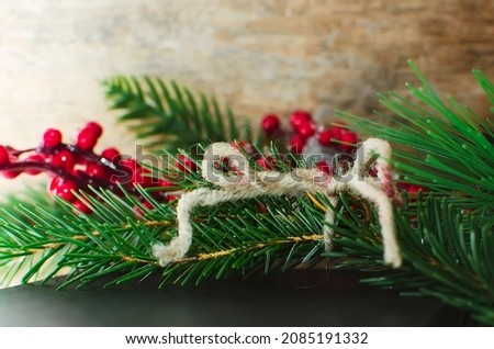 evergreen tree twigs and Christmas decorations with red decorative berries on wooden background. background for web and design use.