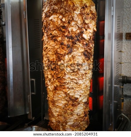 Shawarma. Closeup picture of stacked chicken roasting, shawarma
