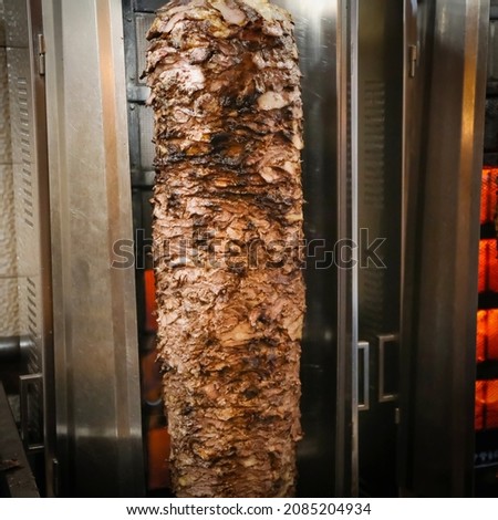 Shawarma. Closeup picture of stacked meat roasting, shawarma
