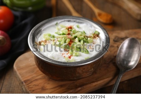 Greek yogurt with cucumber in a bowl on a rustic wooden table. Selective focus
