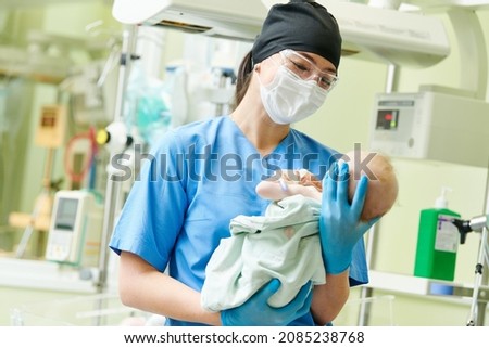 Newborn baby in hospital at neonatal resuscitation center with nurse Royalty-Free Stock Photo #2085238768