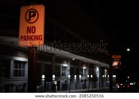 No Parking sign with warm ambient colors in the street at night