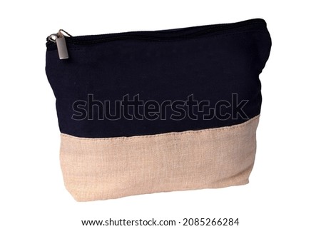 Cosmetic bags. Close-up of a beautiful black and beige cosmetic bag with a brown tag isolated on a white background. Macro. Used for essential equipment brushes for make-up and cosmetic products.